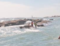 游客爬上礁石观看海景 返回时通道已被潮水淹没
